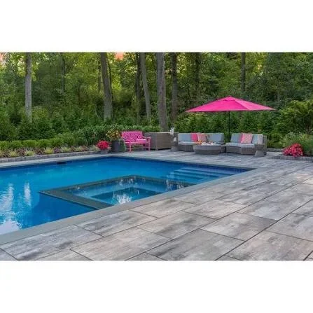 In-ground pool with spa and steps surrounded by gray large-format pavers, lounge seating, and pink umbrella